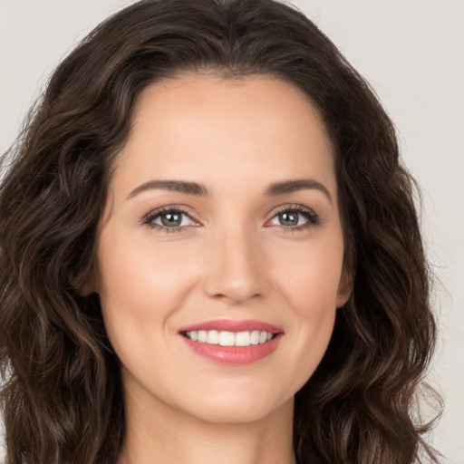 Joyful white young-adult female with long  brown hair and brown eyes