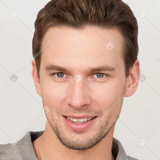 Joyful white young-adult male with short  brown hair and grey eyes