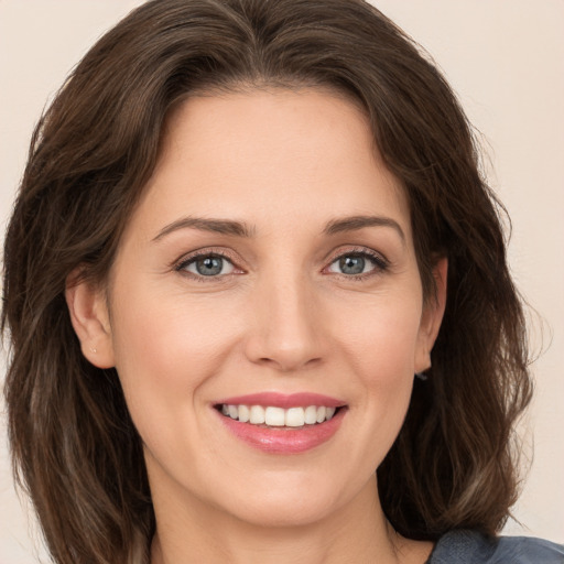 Joyful white young-adult female with medium  brown hair and grey eyes