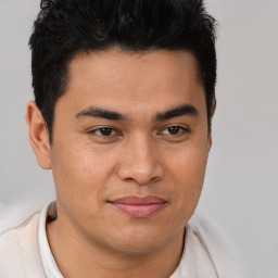 Joyful latino young-adult male with short  brown hair and brown eyes