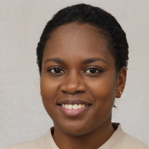 Joyful black young-adult female with short  black hair and brown eyes