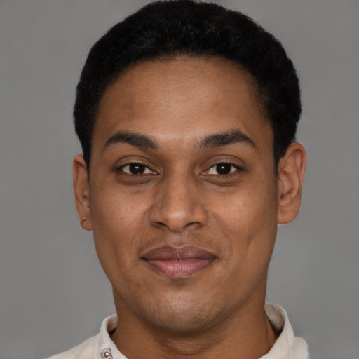 Joyful black young-adult male with short  brown hair and brown eyes