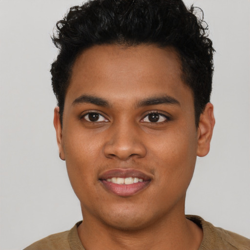 Joyful black young-adult male with short  black hair and brown eyes