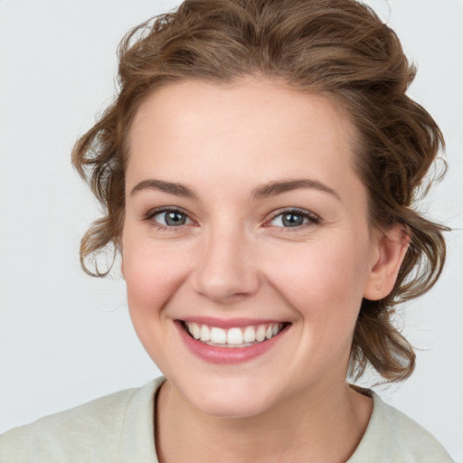 Joyful white young-adult female with medium  brown hair and blue eyes