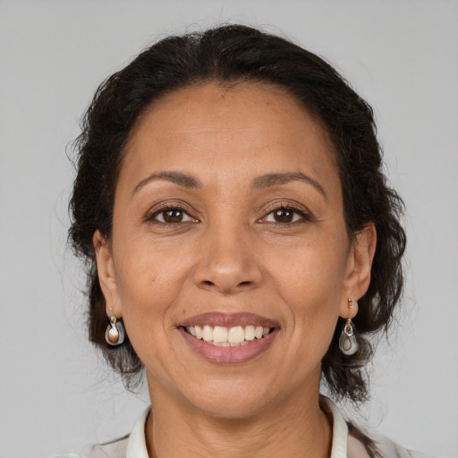 Joyful latino adult female with medium  brown hair and brown eyes