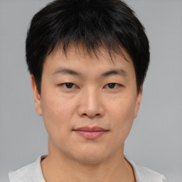 Joyful asian young-adult male with short  brown hair and brown eyes