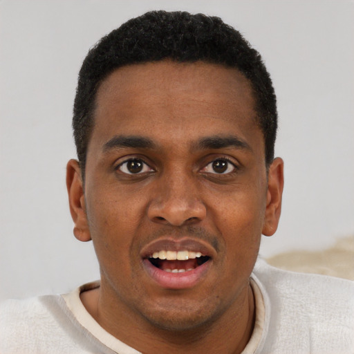 Joyful black young-adult male with short  brown hair and brown eyes