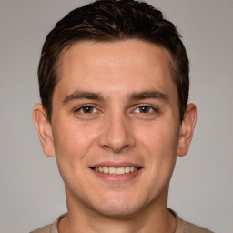 Joyful white young-adult male with short  brown hair and grey eyes