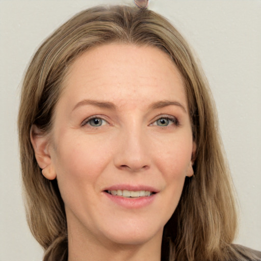 Joyful white adult female with long  brown hair and grey eyes