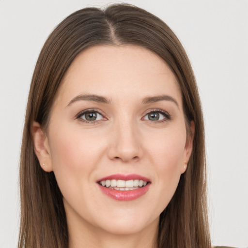 Joyful white young-adult female with long  brown hair and grey eyes