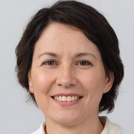 Joyful white adult female with medium  brown hair and brown eyes