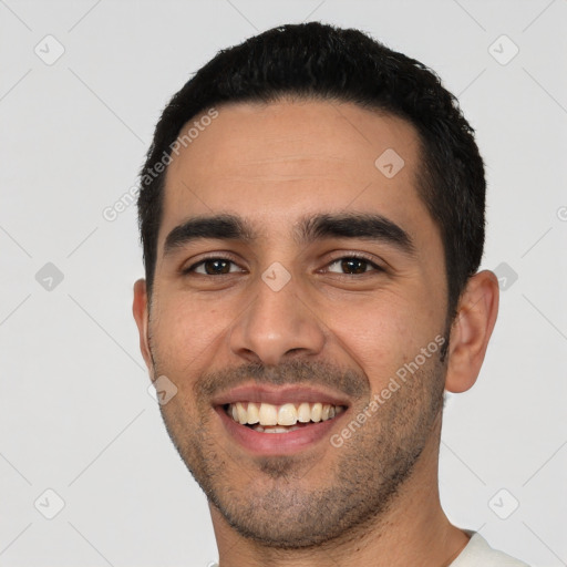 Joyful latino young-adult male with short  black hair and brown eyes