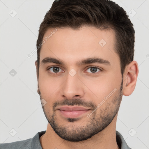 Joyful white young-adult male with short  brown hair and brown eyes