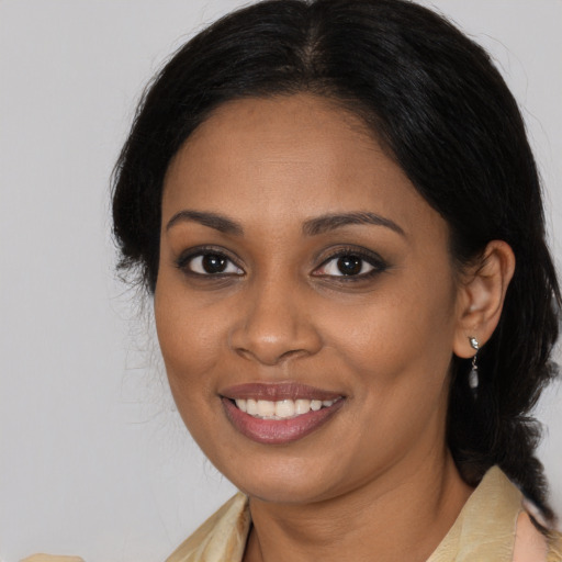 Joyful black young-adult female with medium  brown hair and brown eyes
