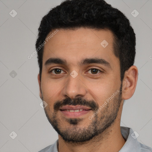 Joyful white young-adult male with short  black hair and brown eyes