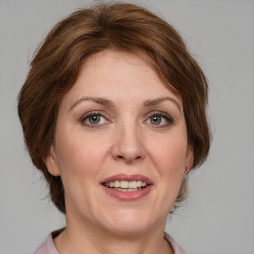 Joyful white adult female with medium  brown hair and blue eyes