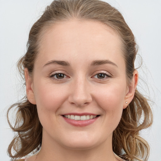 Joyful white young-adult female with long  brown hair and grey eyes