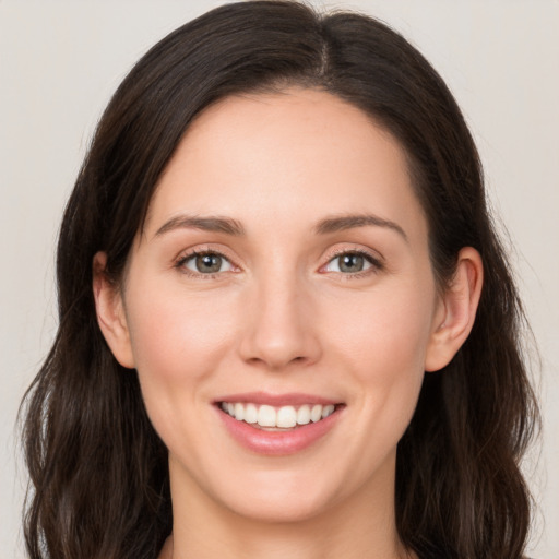 Joyful white young-adult female with long  brown hair and grey eyes