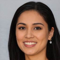 Joyful latino young-adult female with long  brown hair and brown eyes