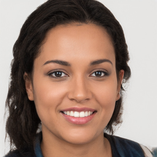 Joyful latino young-adult female with long  brown hair and brown eyes