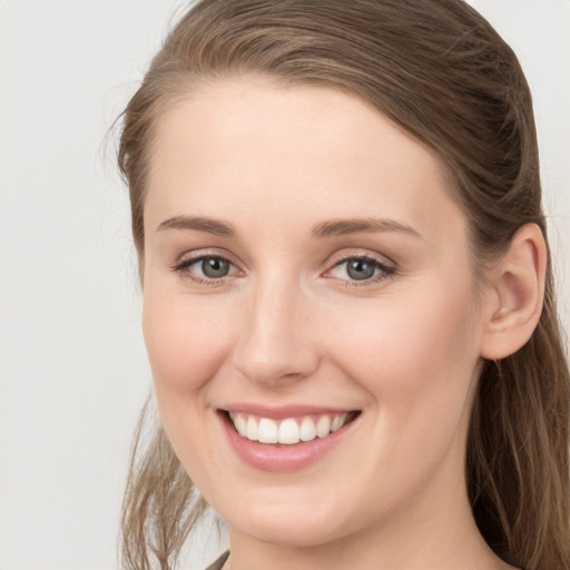 Joyful white young-adult female with long  brown hair and grey eyes