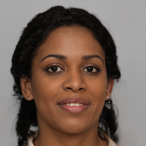 Joyful black young-adult female with long  black hair and brown eyes
