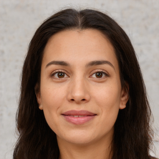 Joyful white young-adult female with long  brown hair and brown eyes