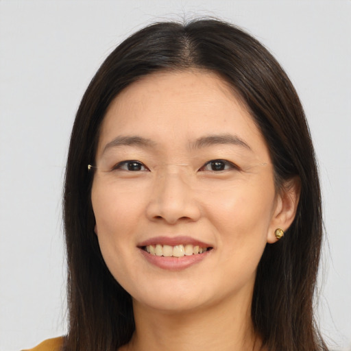 Joyful asian young-adult female with long  brown hair and brown eyes