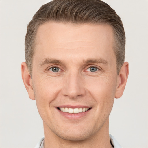 Joyful white adult male with short  brown hair and grey eyes