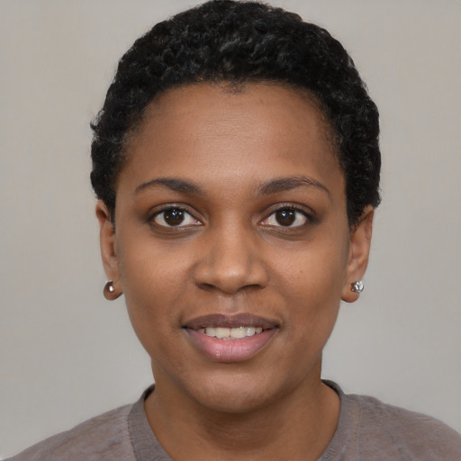 Joyful black young-adult female with short  black hair and brown eyes