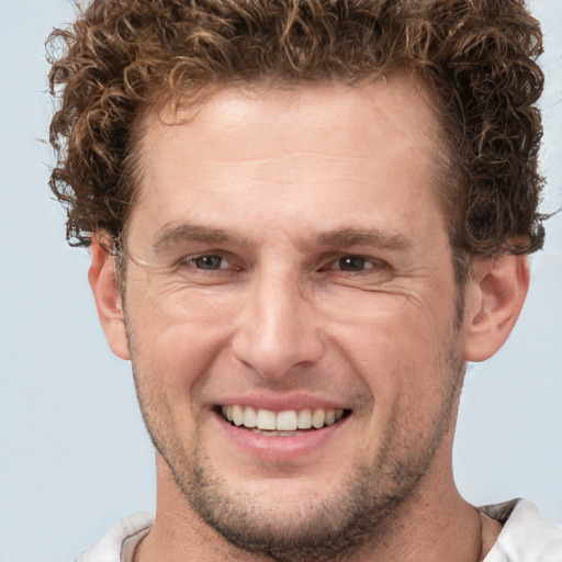 Joyful white adult male with short  brown hair and brown eyes