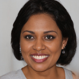 Joyful black young-adult female with medium  brown hair and brown eyes