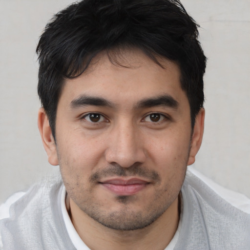 Joyful white young-adult male with short  black hair and brown eyes