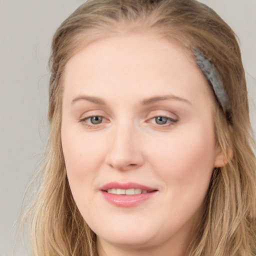 Joyful white young-adult female with long  brown hair and blue eyes