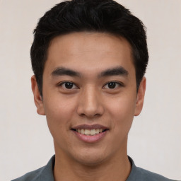 Joyful asian young-adult male with short  black hair and brown eyes