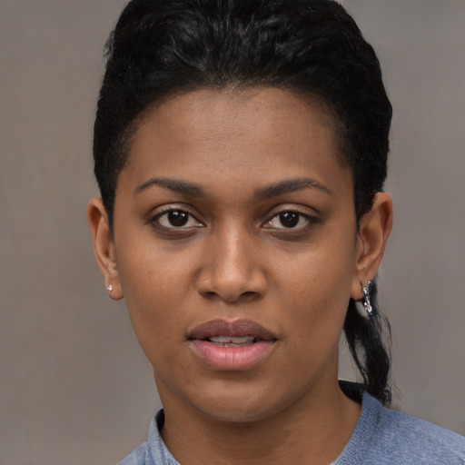 Joyful black young-adult female with short  black hair and brown eyes