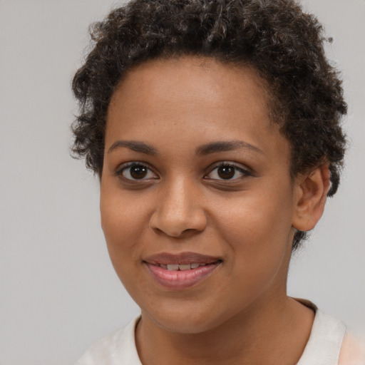 Joyful black young-adult female with short  brown hair and brown eyes