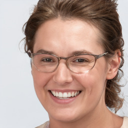 Joyful white adult female with medium  brown hair and blue eyes