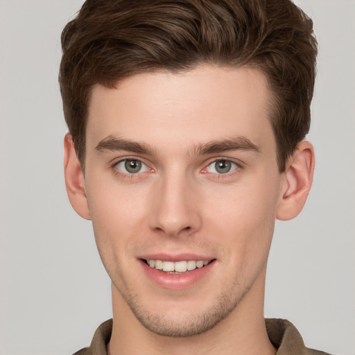 Joyful white young-adult male with short  brown hair and grey eyes