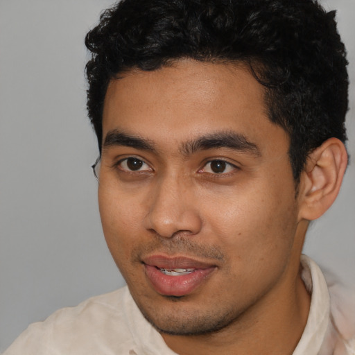 Joyful latino young-adult male with short  brown hair and brown eyes