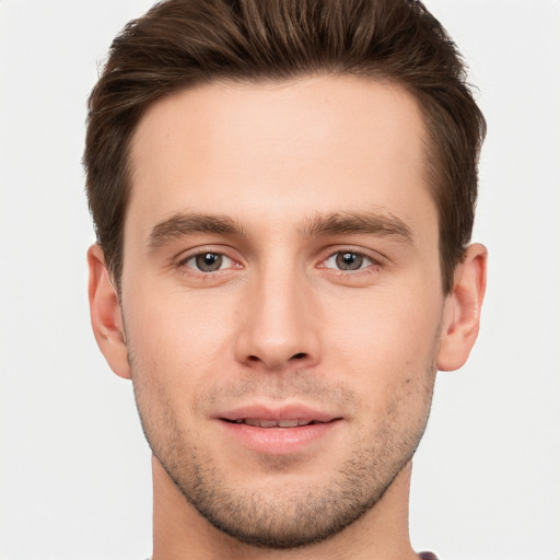 Joyful white young-adult male with short  brown hair and grey eyes