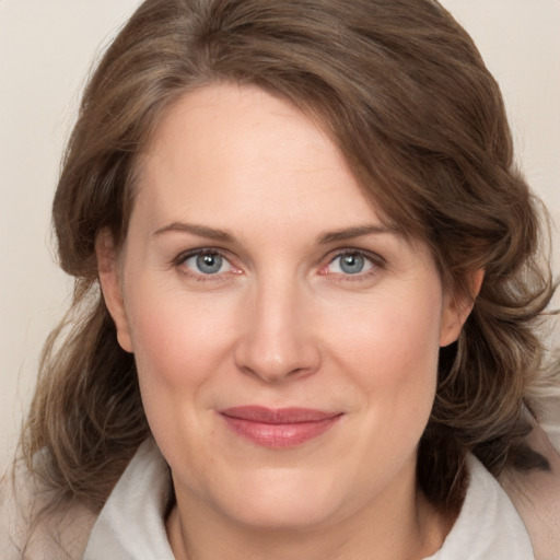 Joyful white adult female with medium  brown hair and grey eyes