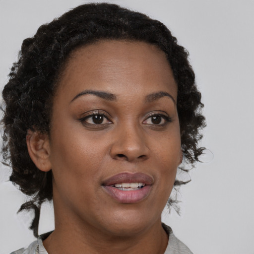 Joyful black young-adult female with medium  brown hair and brown eyes