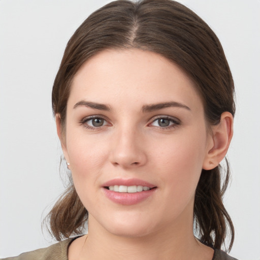 Joyful white young-adult female with medium  brown hair and grey eyes