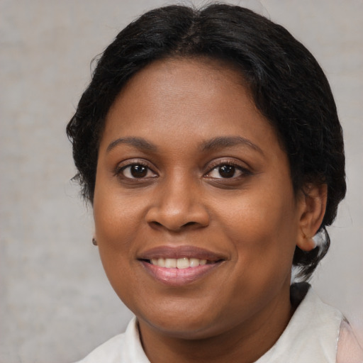 Joyful black adult female with short  brown hair and brown eyes
