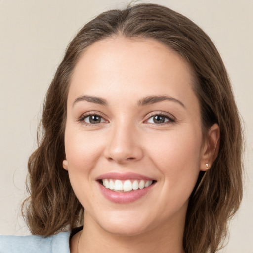 Joyful white young-adult female with medium  brown hair and green eyes