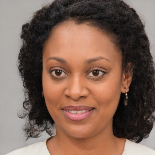 Joyful black young-adult female with medium  brown hair and brown eyes