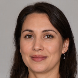 Joyful white adult female with long  brown hair and brown eyes