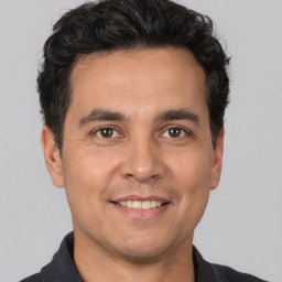 Joyful white adult male with short  black hair and brown eyes