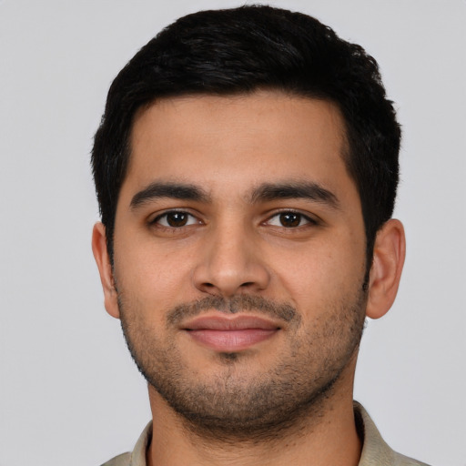 Joyful latino young-adult male with short  black hair and brown eyes